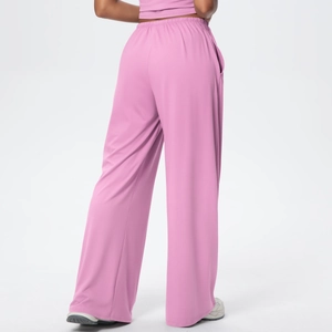 Detail of high waist elastic waistband on draped wide leg trousers in dusty pink