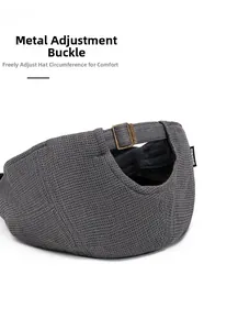 Detail of adjustable bronze metal buckle and waffle texture on dark grey beret cap