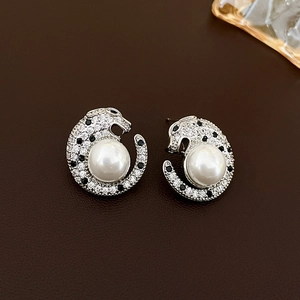Macro shot of silver cheetah stud earring featuring black and white cubic zirconia and a large pearl