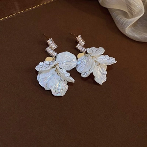 Detail view of elegant white petal tassel earrings with sparkling zircon crystals