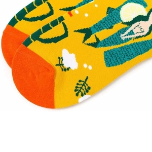 Close-up of seamless orange toe cap and colorful knitted mermaid pattern on yellow cotton socks