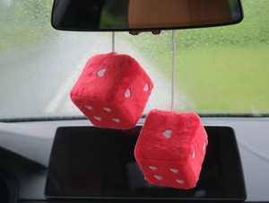Detail of red plush heart dice hanging ornament for car interior rearview mirror decor