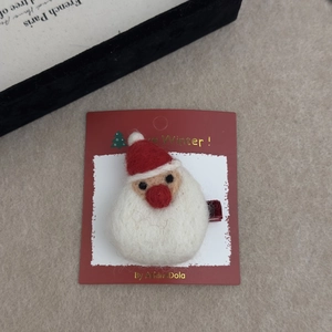 Detail of wool felt Santa Claus hair clip on red card with festive winter theme