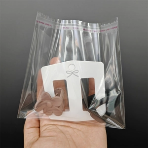 Brown flower hair claw clips displayed on white bow-tie paper card in clear adhesive bag