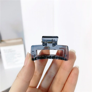 Detail of a translucent dark grey square claw clip with a durable metal spring