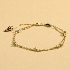 Double-layered gold chain bracelet with polished beads and a stylish cone spike charm