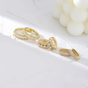 Three pairs of gold-plated copper hoop earrings with sparkling zircon inlay on white stone