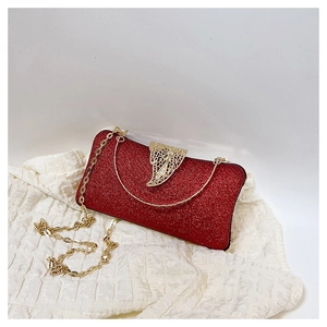 Detail of red glitter evening clutch with golden leaf clasp and chain strap