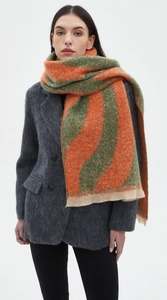 Detail of soft wave pattern scarf in orange and green knit fabric with fringe edges