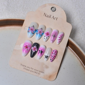 Detail view of almond press-on nails featuring 3D floral textures and gradient patterns