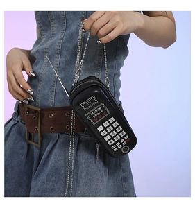Détail du sac bandoulière rétro en forme de téléphone noir avec chaîne argentée chic