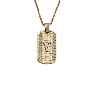 Détail d'un pendentif plaque dorée avec la lettre V sertie de zircons étincelants