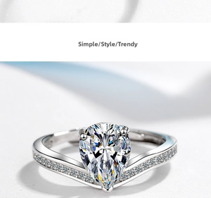 Macro shot of silver ring featuring a pear-cut cubic zirconia and pavé diamond band