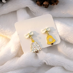Detail of Christmas earrings featuring asymmetric enamel tree and bell with white bows
