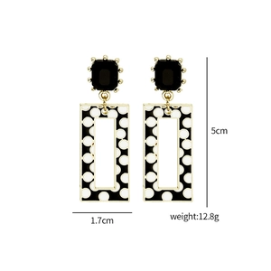 Detailed view of geometric black and white polka dot earrings with size measurements