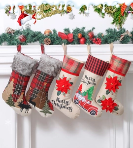 Five assorted Christmas stockings with deer and poinsettia hanging on a festive mantel