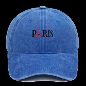 Detail of red Eiffel Tower embroidery and Paris text on blue washed cotton baseball cap