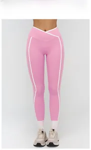 Dettaglio dei pantaloni da yoga rosa con vita a incrocio e strisce laterali bianche