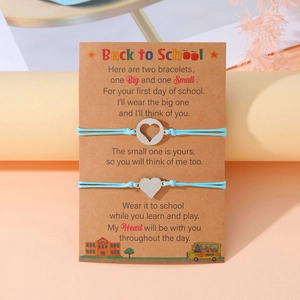 Dettaglio di braccialetti blu per la scuola con ciondoli a cuore su cartolina
