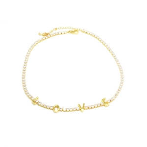 Detail of gold tennis chain necklace with LOVE lettering and white zircon stones