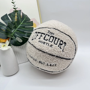 Detail of off-white plush basketball with black embroidered hustle quote design