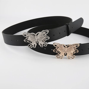 Detail of elegant butterfly buckle on thin black waist belts in gold and silver finish