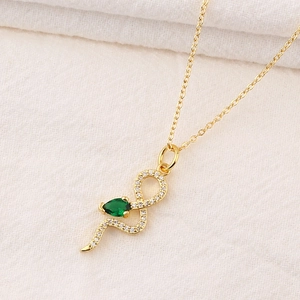 Collier serpent doré avec pendentif goutte émeraude et détails en cristaux brillants