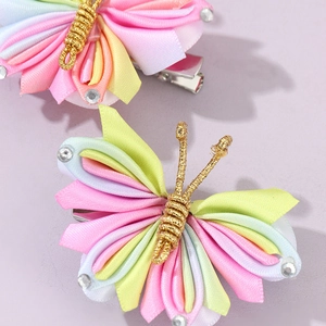 Detail of handmade rainbow gradient butterfly hair clips with sparkling crystal rhinestones
