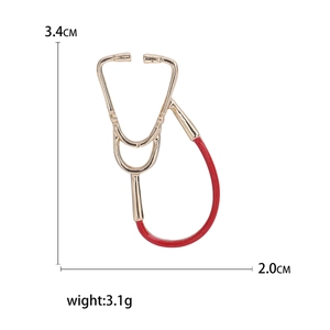 Golden stethoscope brooch with red enamel detail, sized 3.4cm x 2.0cm and weighing 3.1g