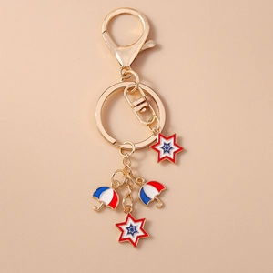 Detail of gold keychain with red, white, and blue enamel stars and umbrellas charms