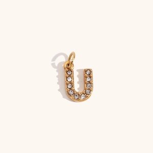 Primer plano de colgante letra U bañado en oro 18K con cristales brillantes