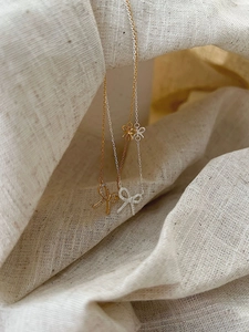Detailed macro view of gold and silver bow pendants with shimmering cubic zirconia stones