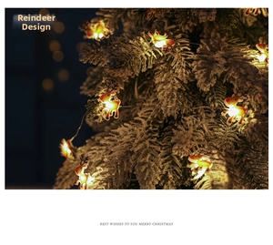 Detail of warm yellow LED reindeer string lights on a snowy Christmas tree branch