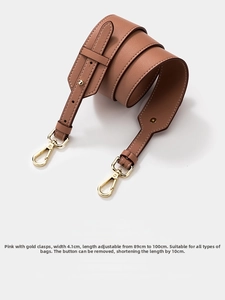 Close-up of pink cowhide wide shoulder strap with adjustable length and gold clasps