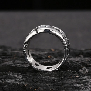Macro shot of silver punk ring with vintage texture on a dark textured rock surface