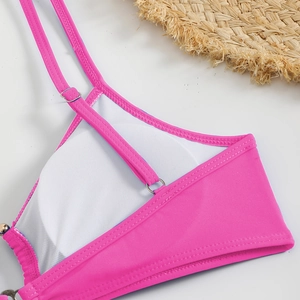 Detailed macro view of pink bikini top with adjustable straps and breathable lining