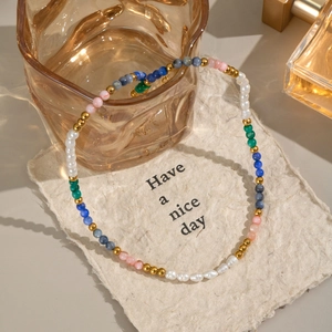 Detail of stone and pearl necklace on vintage paper with Have a nice day text