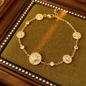 Detail of 18K gold plated bracelet with starburst charms and cubic zirconia on velvet
