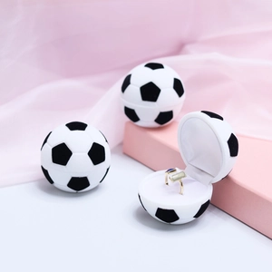 Detail of soccer ball jewelry box with soft velvet interior and ring slot on pink satin
