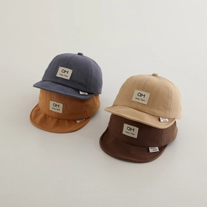 Flat lay of soft cotton baby baseball caps in blue, yellow, beige and brown colors