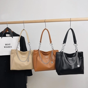 Three minimalist large capacity tote bags in beige, brown and black with chain detail