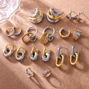 Vue macro de boucles d'oreilles bicolores en acier inoxydable avec jeux d'ombres élégants