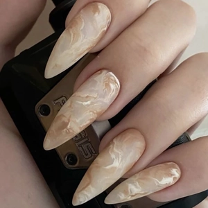 Faux ongles longs stiletto avec un design élégant de texture marbre blanc et nude
