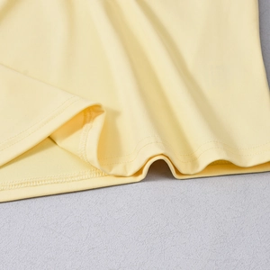 Close-up of light yellow knitted fabric showing detailed stitching and soft texture