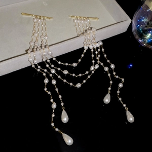 Close-up of elegant pearl tassel hair clips with golden metal base and waterdrop pearls