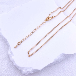 Detail view of the gold lobster clasp and adjustable extension chain on the necklace