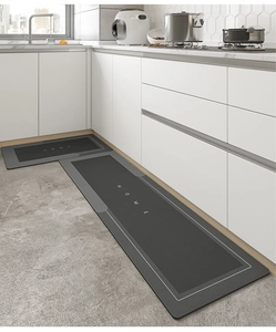Detail view of two-piece dark grey kitchen rugs with HOME text and non-slip backing