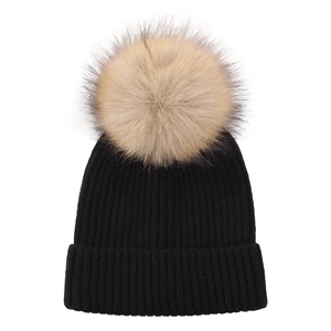Close-up of black ribbed knit beanie with a fluffy light brown faux fur pompom detail