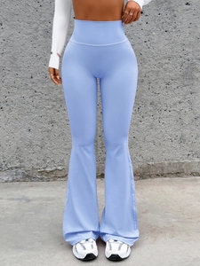 Detail of light blue high-waisted flared yoga pants with smooth stretch fabric