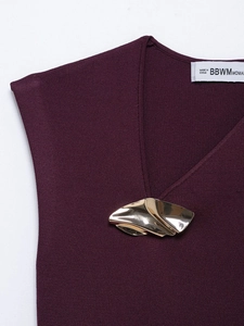 Detailed macro shot of deep purple knit top showing V-neckline and gold metal buckle